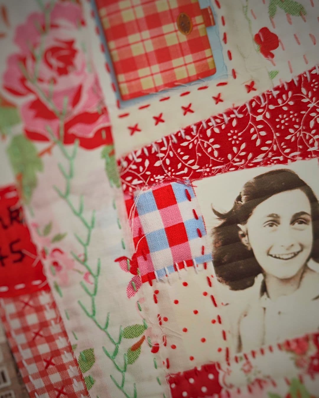 A close up of a quilt collage with a photo of Anne Frank on it.