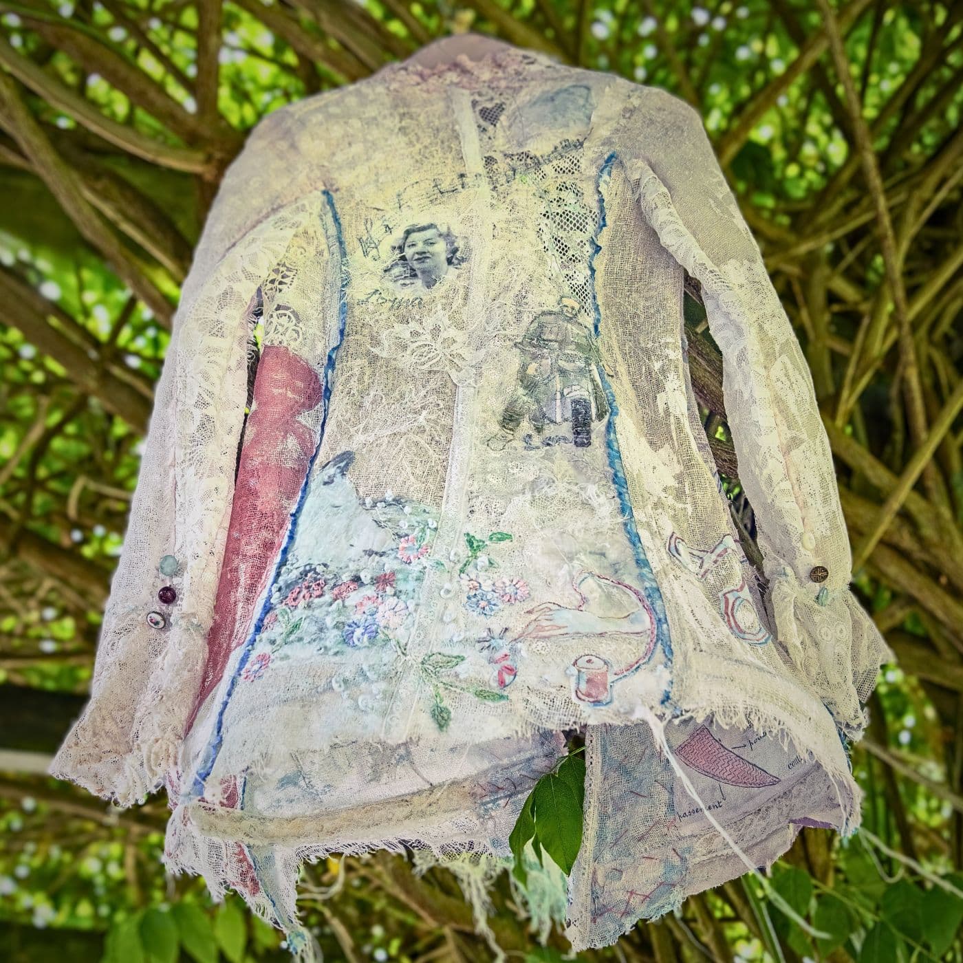 An art installation of a white shirt embellished with stitches in a meadow.