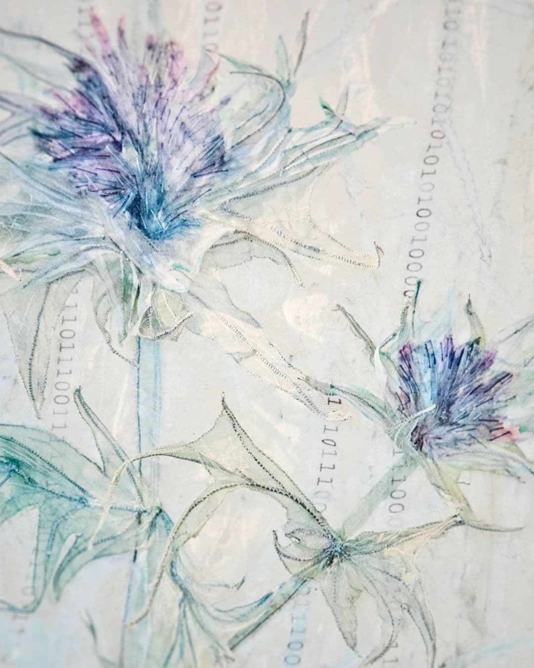 A close up of a stitched artwork flower on a white background