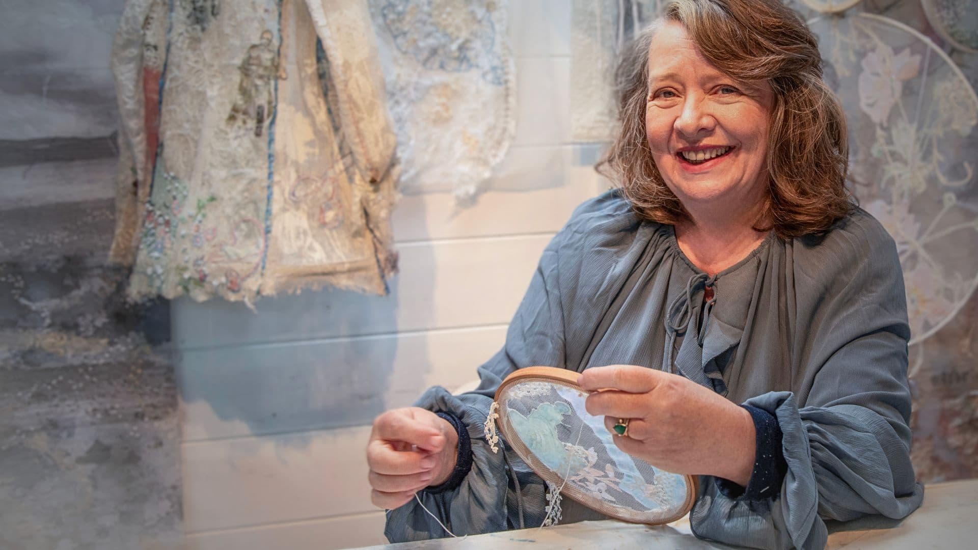 a woman smiling while holding a needle