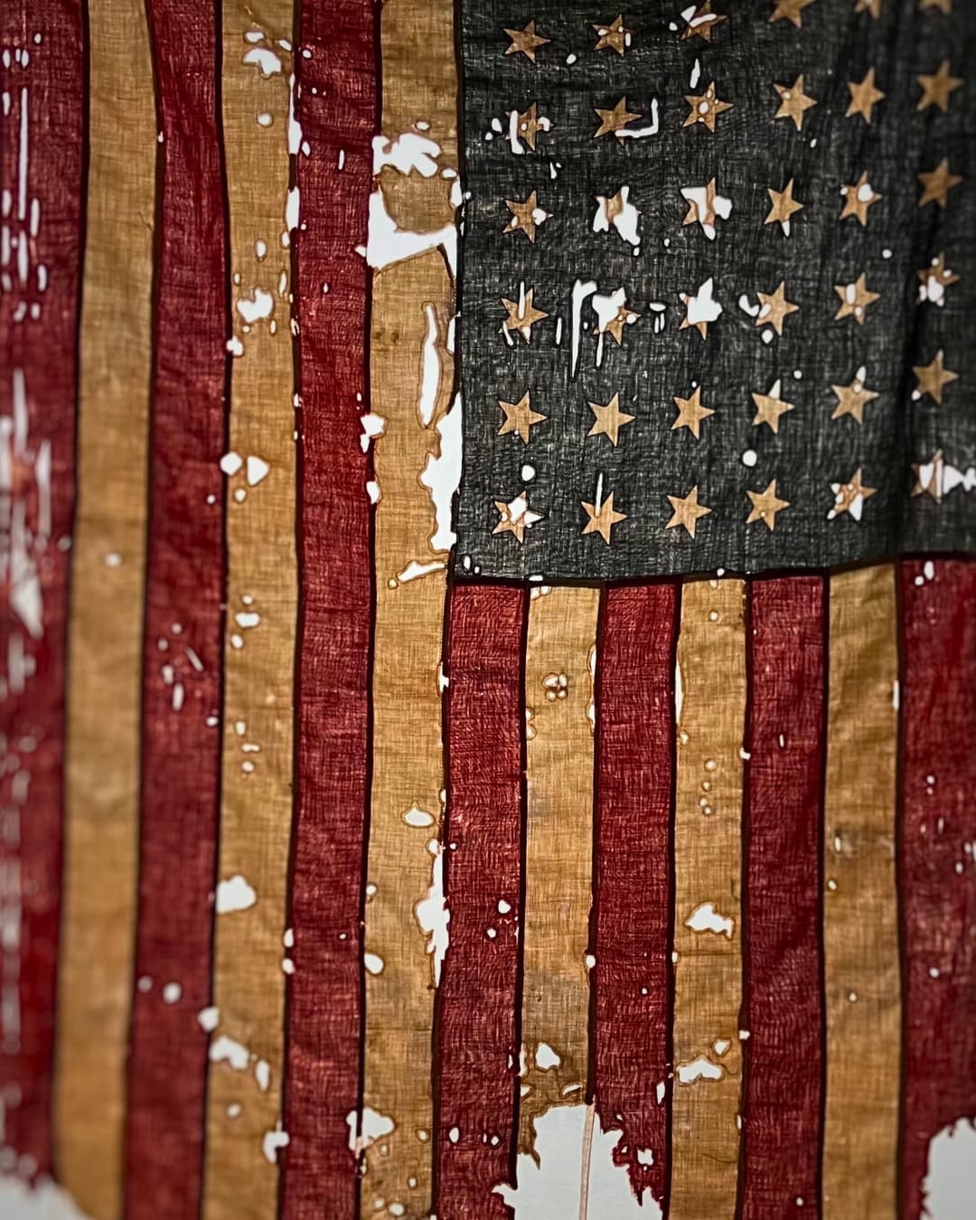 An American flag, frayed and degraded