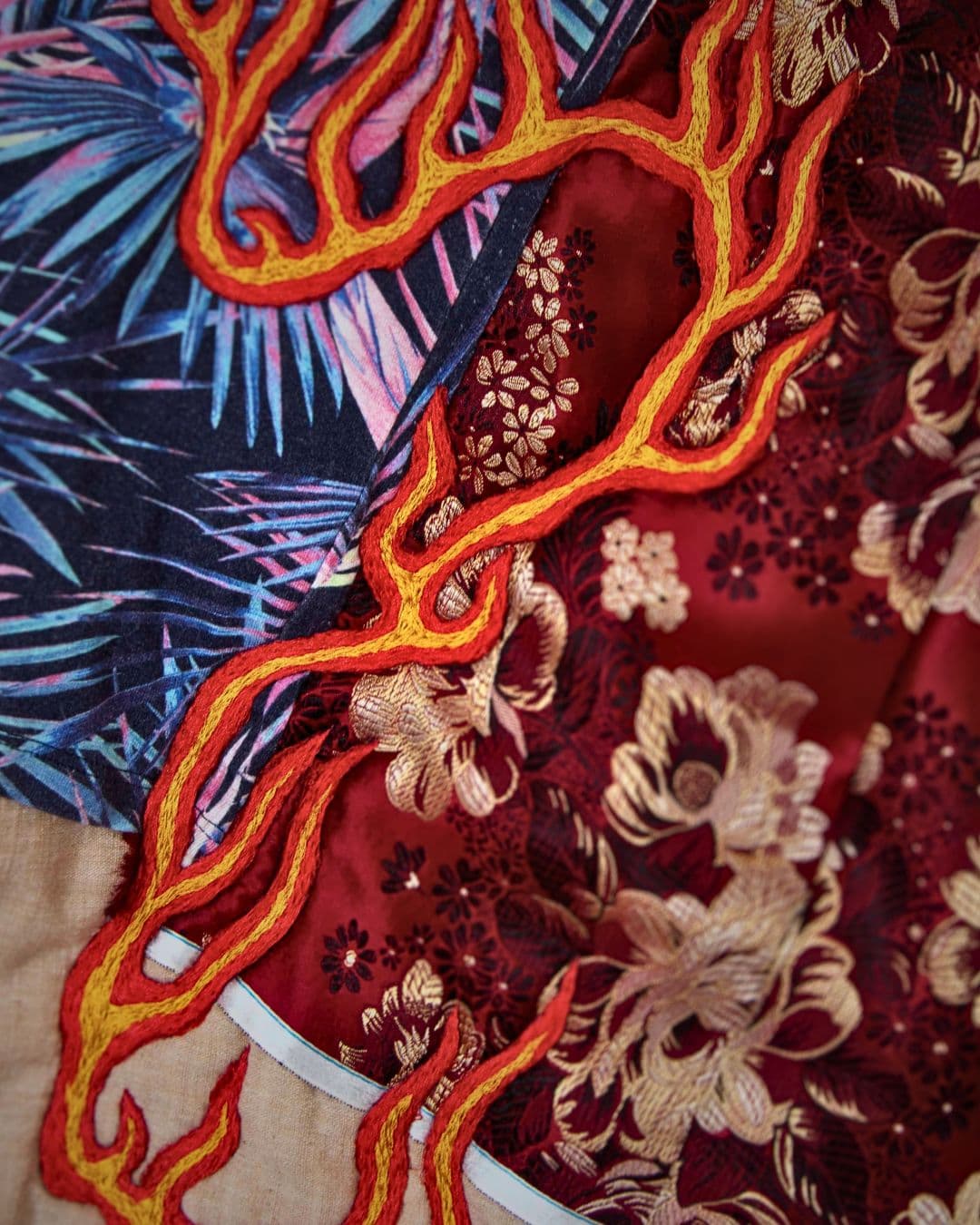 a red and blue fabric with orange threads