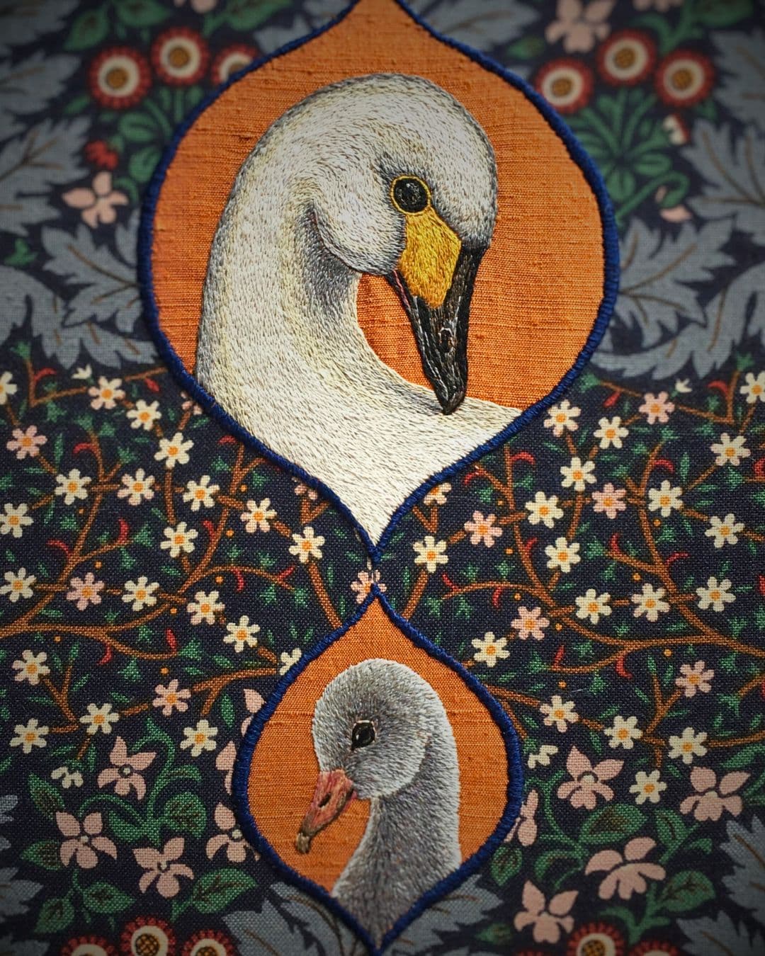 A close up of an embroidered swan and cygnet