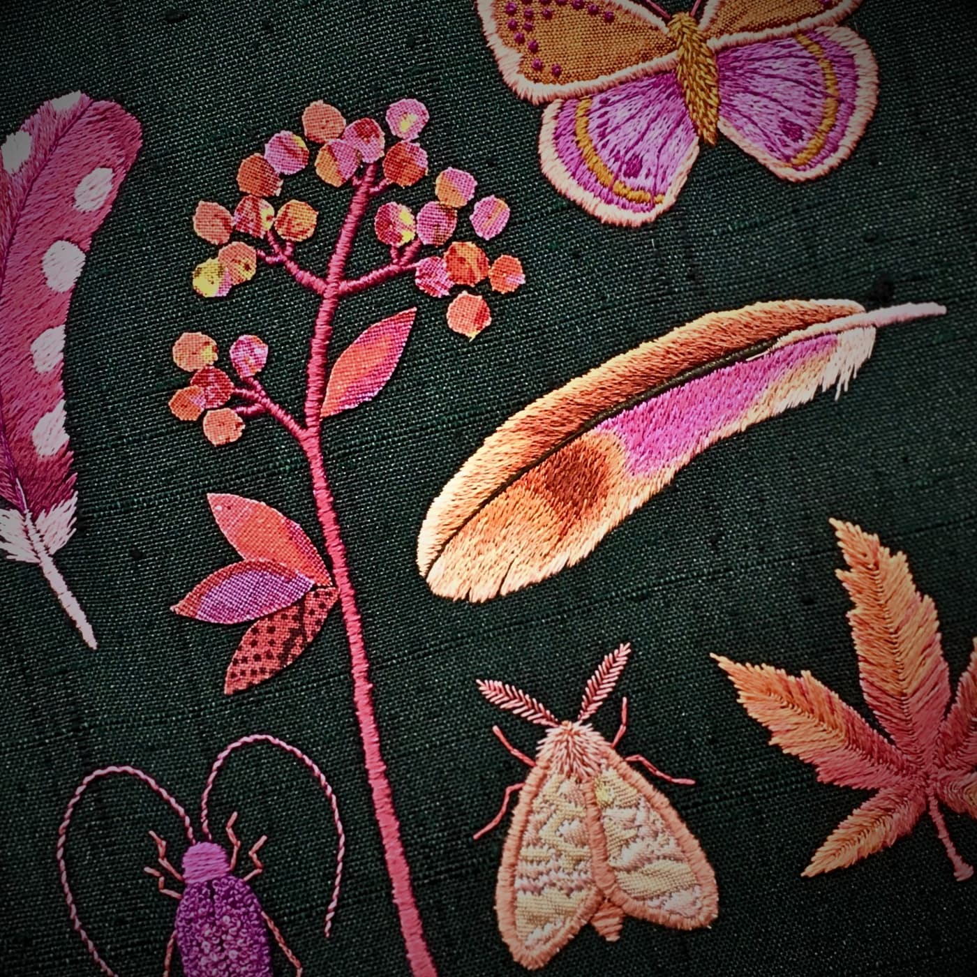 a group of butterflies and flowers embroidered on fabric