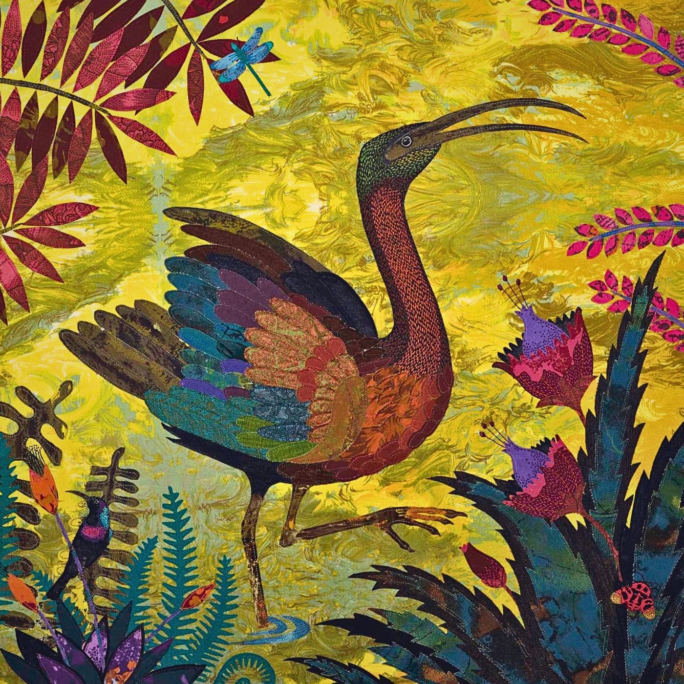 An embroidery of a bird with a long beak surrounded by colourful flowers