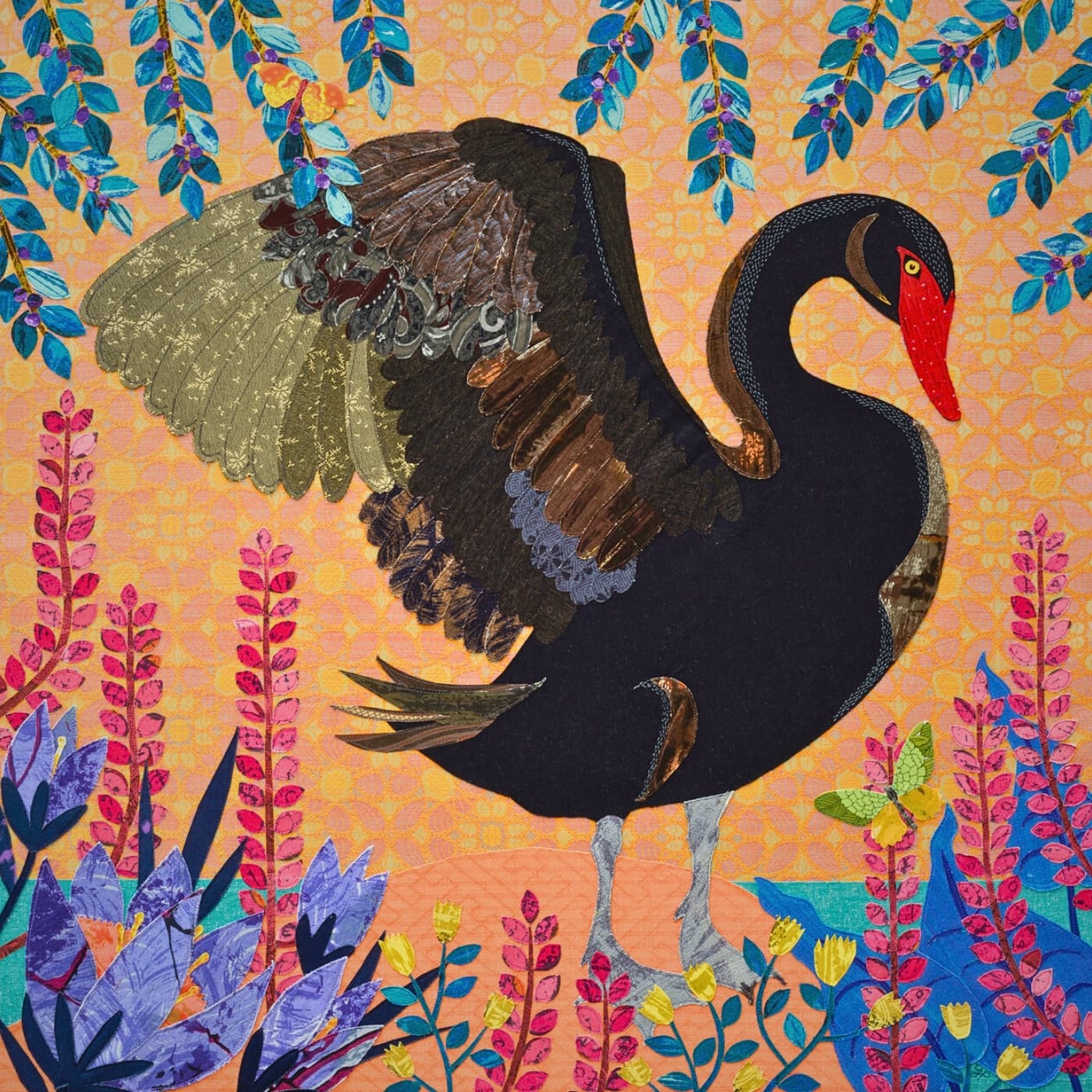 An embroidery of a black swan with a red beak, surrounded by colourful flowers