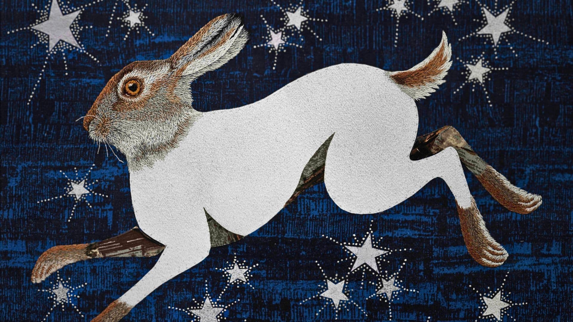 An embroidery of a rabbit on a blue night's sky, starry background.