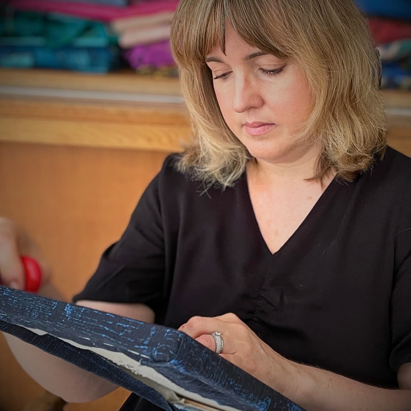 a woman looking at a piece of fabric