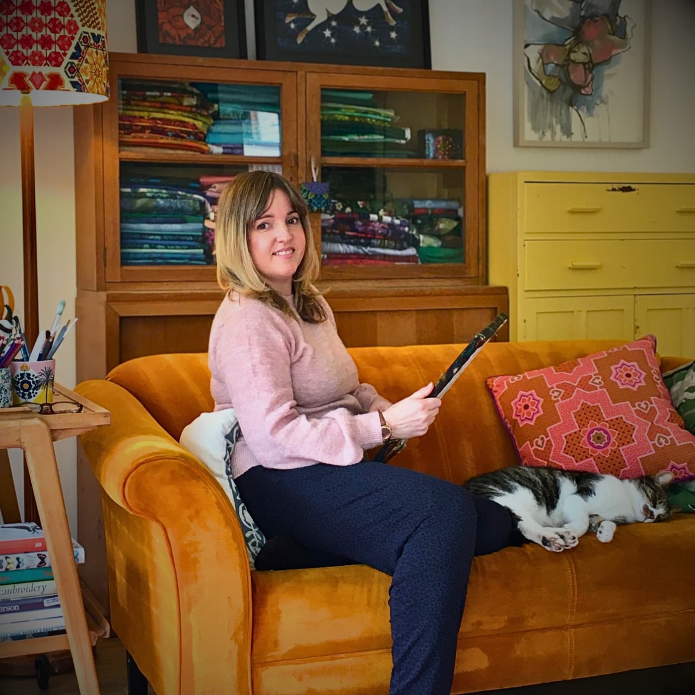 a woman sitting on a couch with a cat on her lap