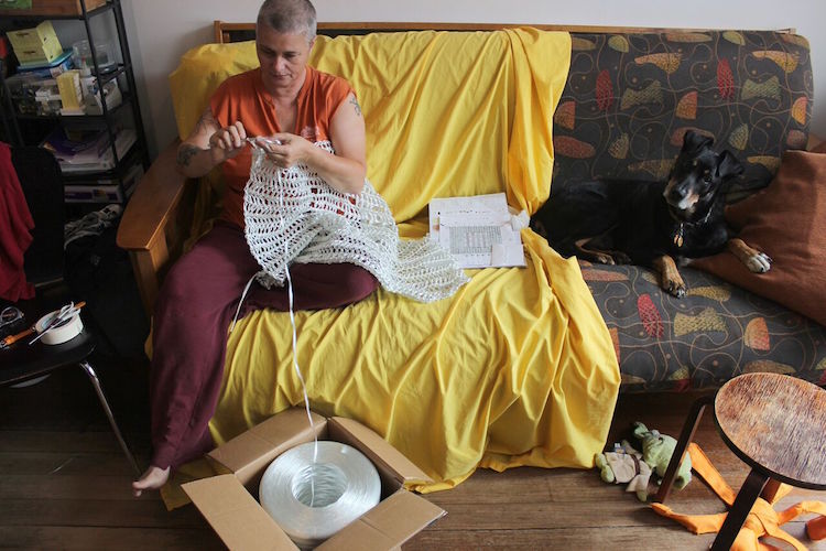 Yvette Kaiser Smith, at home, crocheting fiberglass roving, with Congress the family dog, 2014